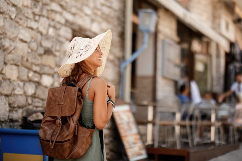 happy woman walking through the town during her summer holiday.
