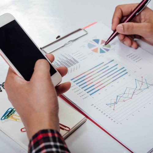close up young man working and smart phone and laptop on wooden